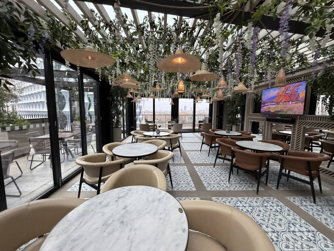 A bright terrace with marble tables and hanging greenery at Embassy Gardens